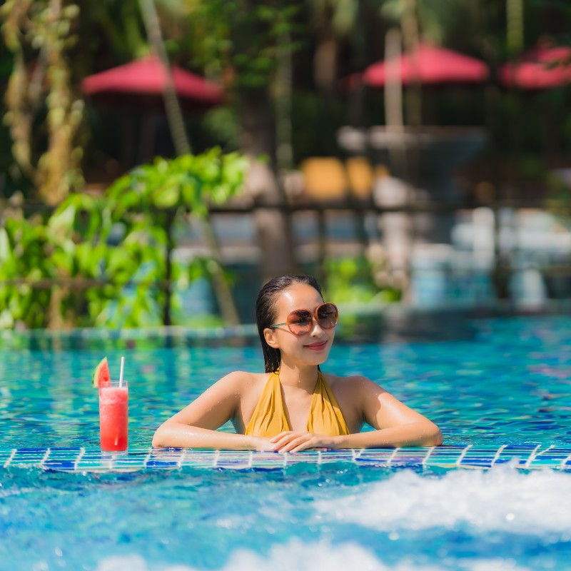 Portrait beautiful young asian woman leisure relax smile with watermelon juice around swimming pool in hotel resort for holiday vacation trip